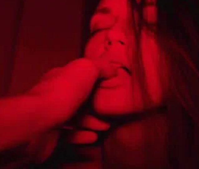 brunette girl, eyes closed, finger sucking, lips biting, red lighting